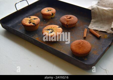 Baked muffins with cinnamon and chocolate on a griddle plate Stock Photo