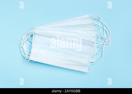 A stack of protective disposable medical masks on a blue background. Stock Photo
