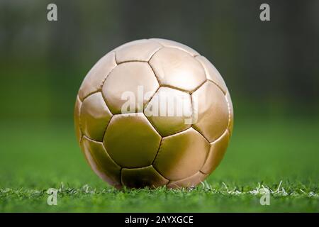 Closeup soccer golden ball in green grass on stadium Stock Photo