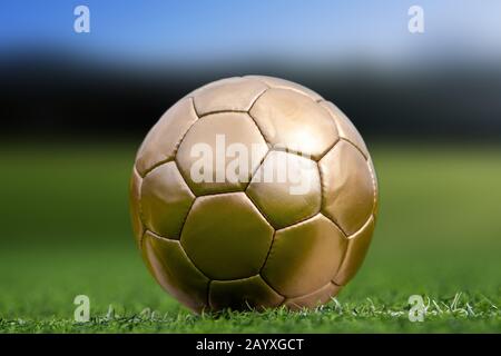 Closeup soccer golden ball in green grass on stadium Stock Photo