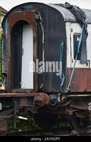 an old passenger carriage awaiting restoration on a siding at Minehead station on the West Somerset Railway. Stock Photo
