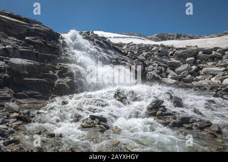 Water streaming down from rocks on a glacier in the Alps Stock Photo