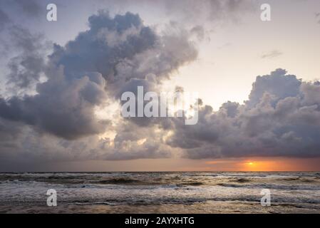 Sunset between clouds and horizon over sea Stock Photo