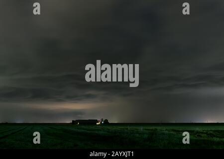 Dark threatening storm clouds over a farm Stock Photo