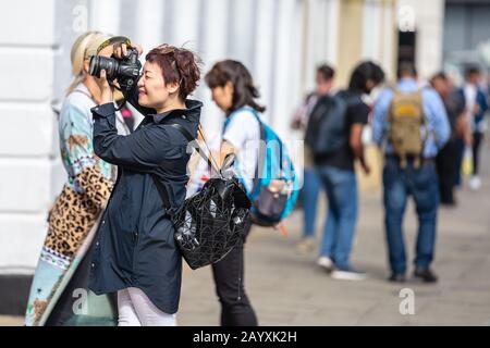 Cambridge, UK, August 1, 2019. Turists walking down and taking pictures at the street of Cambridge on a busy sunny day in front of Kings College Stock Photo