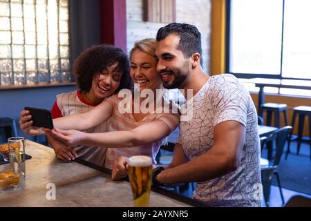 Friends taking selfies together Stock Photo
