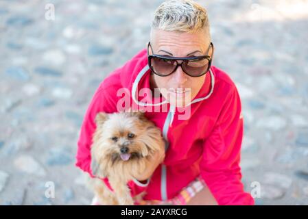 A woman with a little dog in her arms. Stock Photo