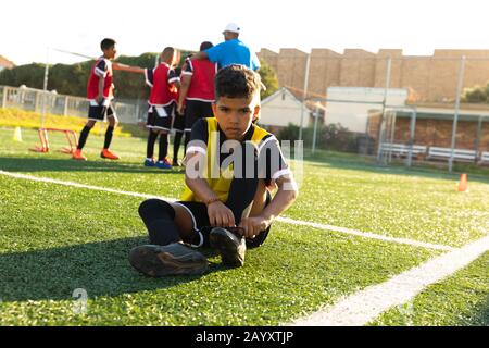Front view soccer player putting on his shoes