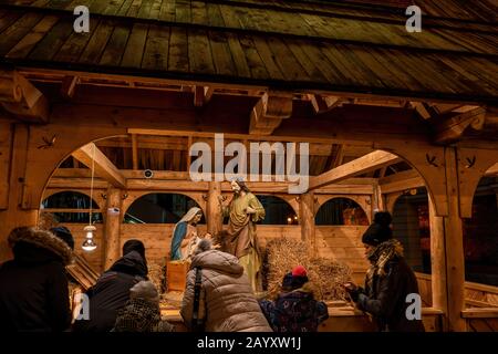 Warsaw, Poland - December 27, 2019: People watching Nativity Scene Christmas crib with baby Jesus, saint Mary and Joseph, public exhibition in the cit Stock Photo