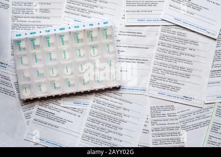 A selection of medical repeat prescription requests issued by a doctor, with a pill organiser. NB data has been anonymised. Stock Photo