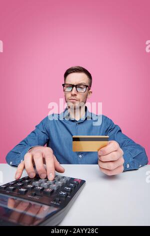 Portrait of cheerful successful young man in jacket making finger guns against blue background Stock Photo