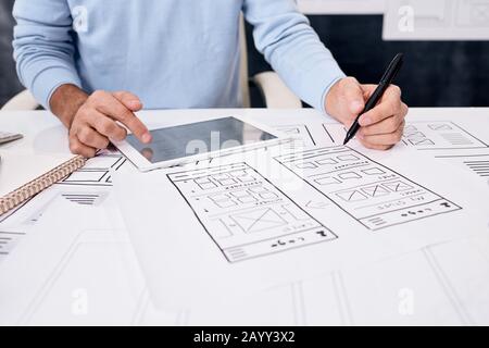 Horizontal shot of unrecognizable application designer working on new app for smartphones and tablets Stock Photo
