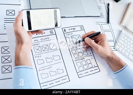 Horizontal high angle shot of unrecognizable software developer working on new application for smartphones Stock Photo