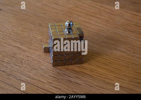Funny thinking out of the box in toy magnet cubes and balls isolated on a wooden background Stock Photo