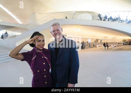 Male Guest poses with 'Flight Attendant Greeter' at Entrance to TWA Hotel, JFK Airport, NYC, USA Stock Photo