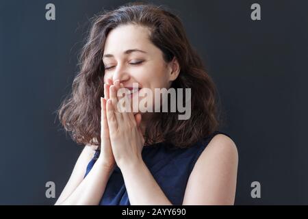 Happy girl smiling. Beauty portrait young happy positive laughing brunette woman on black background isolated. European woman. Positive human emotion facial expression body language. Stock Photo