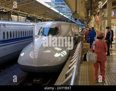 N700 Series Tokaido Shinkansen trains and cleaning crews at Tokyo Statio in Japan.