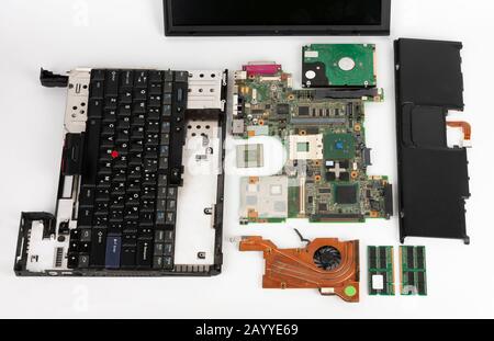 Disassembled laptop, basic components of notebook, screen, keyboard, processor, motherboard, internal  hard disk drive, CPU fan. Stock Photo