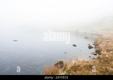 Greendale Tarn on a misty day, in the English Lake District Stock Photo