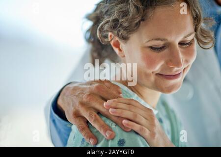 Hand on a doctor comforting a mid adult woman. Stock Photo