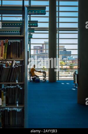 Man reading by a glass window at Burton Barr Central Library in