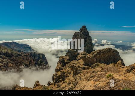 Center of Gran Canaria. Spectacular aerial view of volcanic rocks above the white fluffy clouds. Beautiful sunny day with clear, bright blue sky. Cana Stock Photo