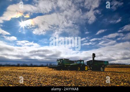 Silhouette of a combine harvester on the field Stock Photo