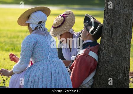 British women treat a injured redcoat soldiers during a reenactment of the American revolution  in a  park Huntington Beach,California, USA Stock Photo