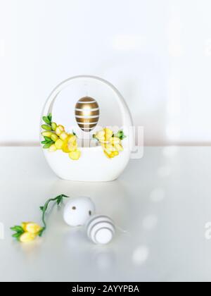 Easter golden stripy egg with polka dots and yellow freesia flower, great design for any purposes. Interior Spring design ideas for home decor. Greeti Stock Photo