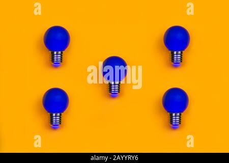 Blue light bulbs on a yellow background. several lightbulbs with copy space Stock Photo