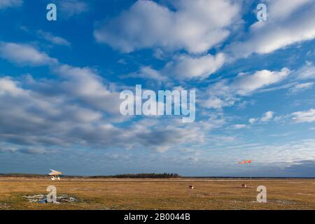 Airfield with a small plane and windsock. Flying adventure Stock Photo