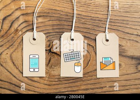 Hangtags with contact option icons on wooden background Stock Photo