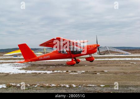 2020-02-09 Byshiv, Ukraine. Small red plane flies from local airfield. Ultralight plane flight Stock Photo