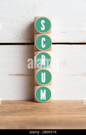 cubes with message SCRUM in front of wooden background Stock Photo