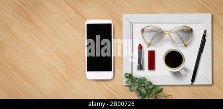 feminine flat lay with smartphone, lipstick, glasses, a coffee and a pen on wooden background Stock Photo