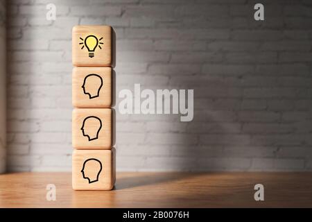 cubes with the person-symbols and lightbulb symbols in front of a brick wall - 3D rendered illustration Stock Photo