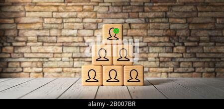 cubes with person-symbols stacked as a pyramid in front of a brick wall - 3D rendered illustration Stock Photo