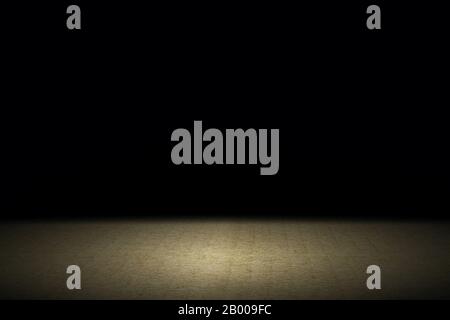 Light shining down on brown carpet floor in dark room with copy space, abstract background Stock Photo