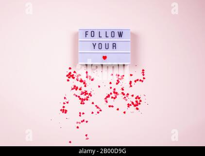 Words fallow your on the light box on a dark background, with little hearts. Place for text, abstract content. Stock Photo