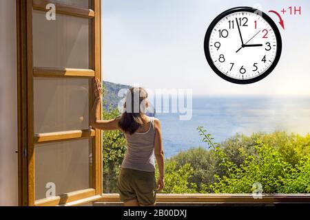 Daylight Saving Time (DST). Blue sky with white clouds and clock. Turn time forward (+1h). Stock Photo