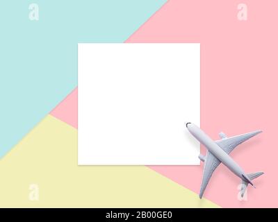 travel by plane concept.simply flat lay design of travel concept with plane on blue , yellow and pink pastel color background with blank white paper f