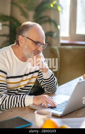 Grey-haired bearded senior man eyeglasses looking serious Stock Photo