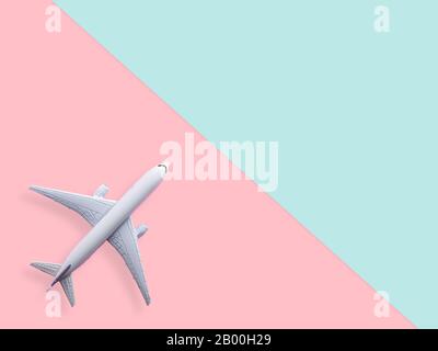 flat lay of white plane model on pastel blue and pink color background with copy space. travel and vacation concept Stock Photo