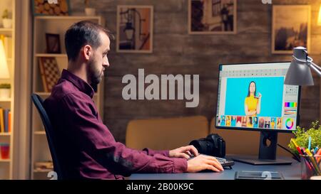 Professional retoucher working on a big project in home office at night time. Stock Photo