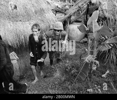 Vietnam: Marine from 1st Battalion, 3rd Marines, moves an alleged NLF activist to the rear during a search and clear operation by the battalion 15 miles (24 km) west of Da Nang Air Base.  The Second Indochina War, known in America as the Vietnam War, was a Cold War era military conflict that occurred in Vietnam, Laos, and Cambodia from 1 November 1955 to the fall of Saigon on 30 April 1975. The war followed the First Indochina War and was fought between North Vietnam, supported by its communist allies, and the government of South Vietnam, supported by the U.S. and other anti-communist nations. Stock Photo