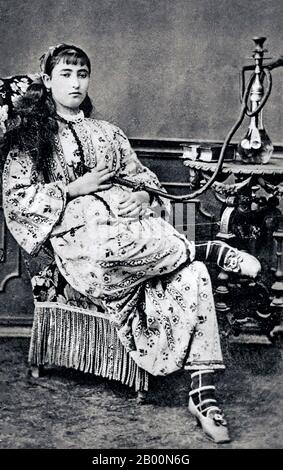 Algeria: Arab woman with hookah pipe, 1880s.  A hookah (Hindustani: huqqah), also known as a waterpipe, is a single or multi-stemmed (often glass-based) instrument for smoking in which the smoke is cooled and filtered by passing through water. The tobacco smoked is referred to as narghile or shisha (sheesha) in the United Kingdom, United States and Canada. Stock Photo