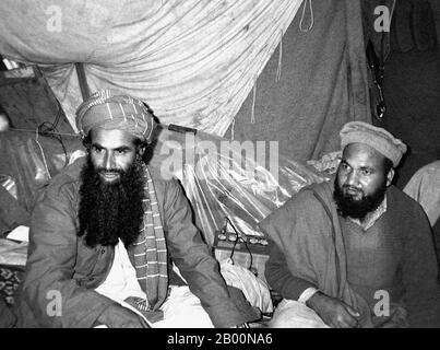 Afghanistan: Mujahideen military commander Abdul Rasul Sayyaf (L) with one of his top lieutenants, Commander Abdullah, Pakti Province, 1984. Photo by Erwin Franzen.  The Soviet War in Afghanistan was a nine-year conflict involving the Soviet Union, supporting the Marxist government of the Democratic Republic of Afghanistan against the indigenous Afghan Mujahideen and foreign ‘Arab–Afghan’ volunteers. The mujahideen found other support from a variety of sources including the United States, Saudi Arabia, the United Kingdom, Pakistan, Egypt, China and other nations, turning it into a proxy war. Stock Photo