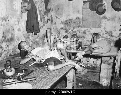 India: Opium smokers in Tangra, Calcutta/Kolkata Chinatown. Photograph by Clyde Waddell, 1945.  Chinatown in the eastern part of the city of Kolkata is the only Chinatown in India. The locality was once home to 20,000 ethnic Chinese, now the population has dropped to 2,000 or so. The traditional occupation of the Chinese community here had been working in the nearby tanning industry and the Chinese restaurants. The area is still noted for the Chinese restaurants where many people flock to taste traditional Chinese and Indian Chinese food. Once there were many opium dens in the area. Stock Photo