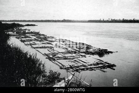 Cambodia: A bamboo raft on the Mekong River at Kampong Cham in 1919.  The River Mekong is the world's 12th-longest river. From its Himalayan source on the Tibetan plateau, it flows some 4,350 km (2,703 miles) through China's Yunnan province, Burma, Laos, Thailand, Cambodia and Vietnam, finally draining in the South China Sea.  The recent construction of hydroelectric dams on the river and its tributaries has reduced the water flow dramatically during the dry season in Southeast Asia. Stock Photo