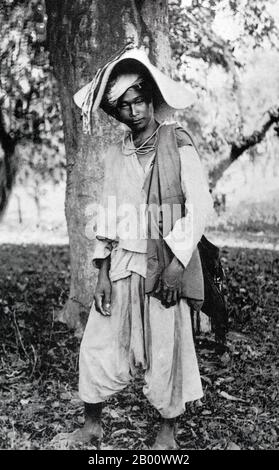 China: An ethnic Tai Lu man photographed in Xishuangbanna, Yunnan Province, in 1920.  The Tai ethnicity refers collectively to the ethnic groups of southern China and Southeast Asia, stretching from Hainan to eastern India and from southern Sichuan to Laos, Thailand, and parts of Vietnam, which speak languages in the Tai family and share similar traditions and festivals, including the water festival. Despite never having a unified nation-state of their own, the peoples also have historically shared a vague idea of a 'Siam' nation, corrupted to Shan or Assam in some places. Stock Photo